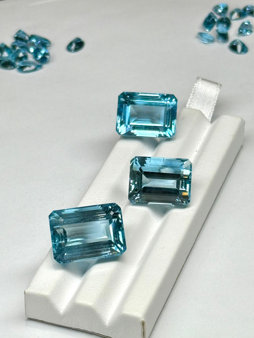 Three emerald-cut aquamarines with loose melee stones