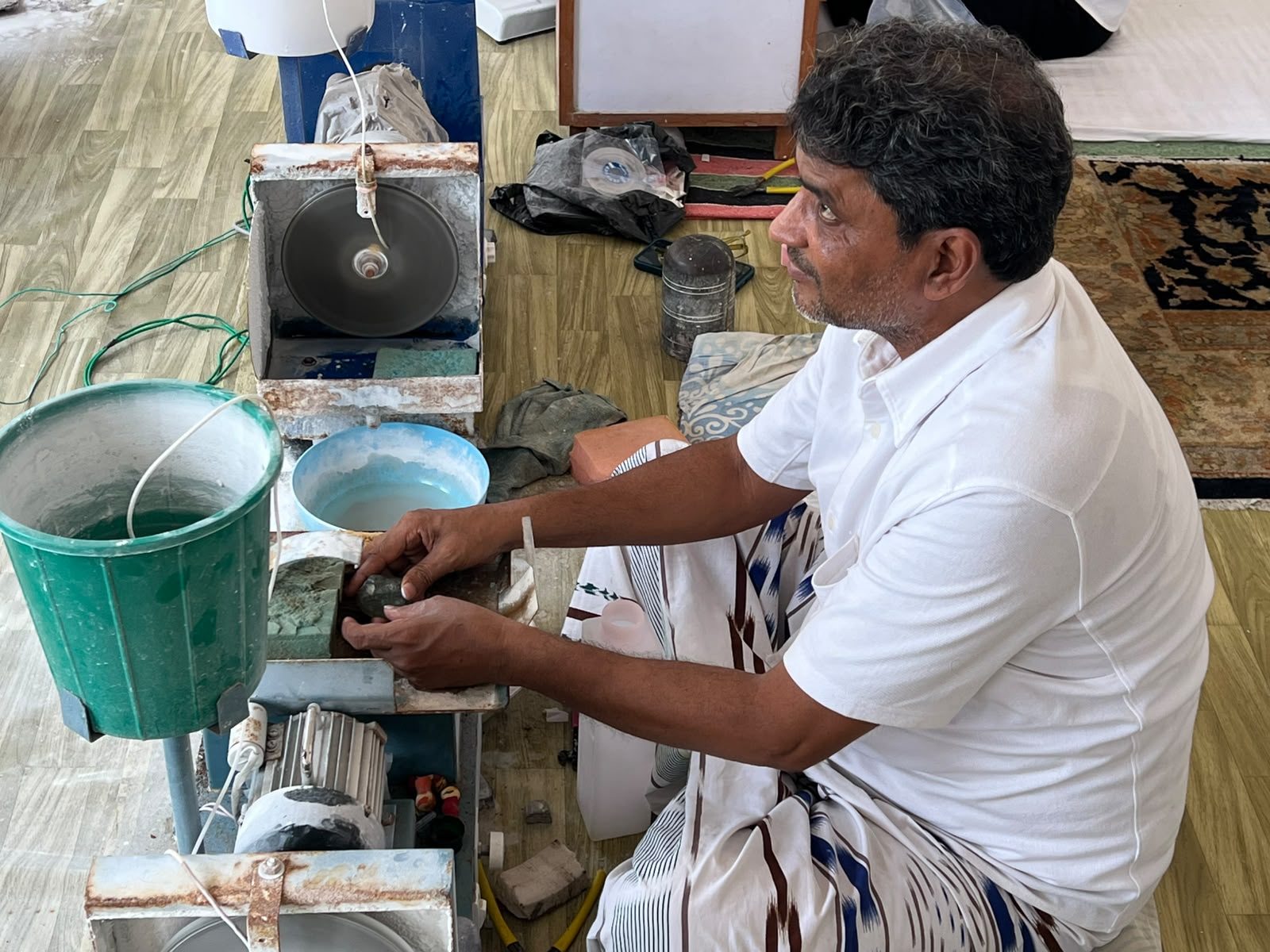 Cutter examining a rough aquamarine piece
