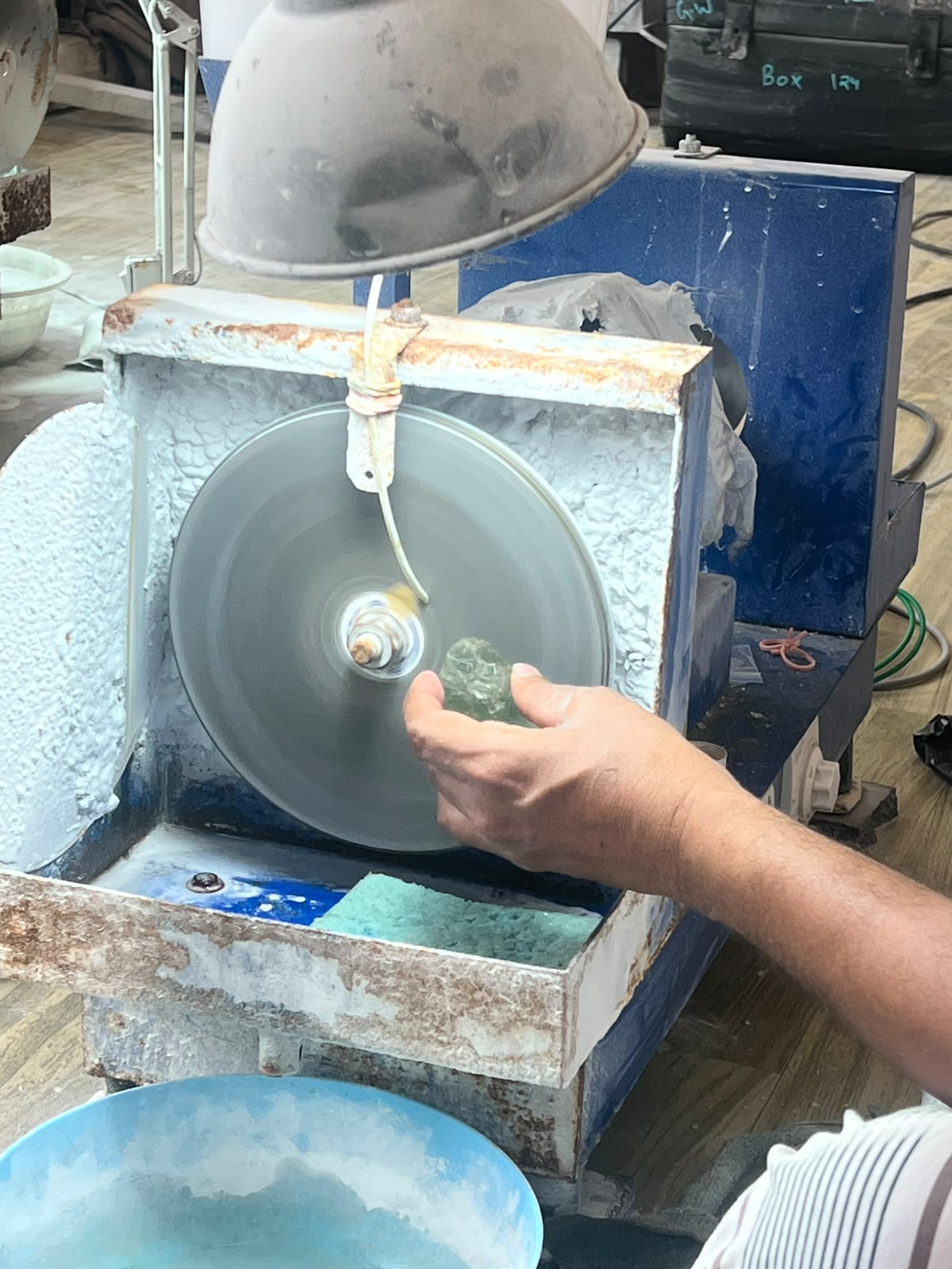 Close-up of aquamarine being ground on the faceting wheel